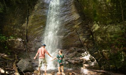 Two people at the base of Cascade Lake Falls