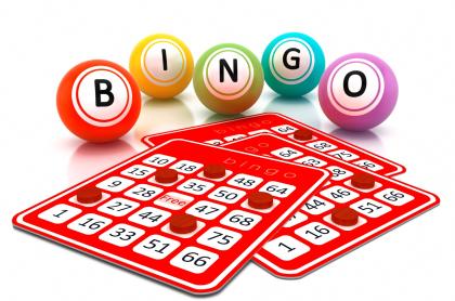 Three BINGO cards with red dots on some of the spaces with five large balls in the background spelling out BINGO