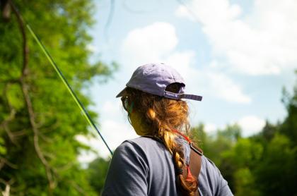 A woman holds a fishing pole.