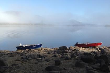 Two boats resting on the shore of Indian Lake Islands State Campground on a foggy morning