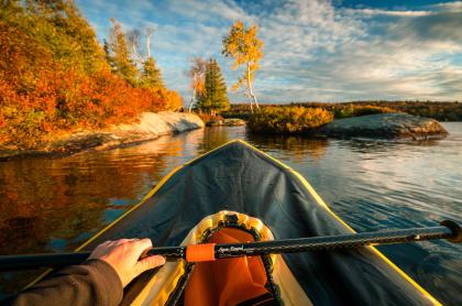 A first person view of paddling a pack raft during sunset.