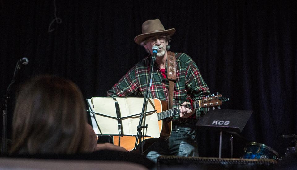 A man performs with a guitar.