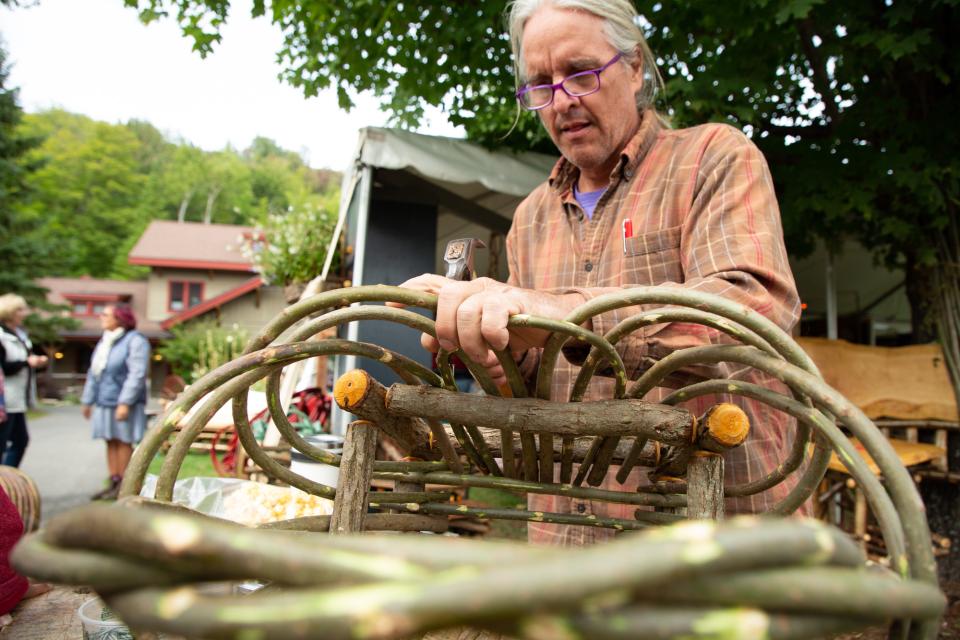 Man making furniture from slim branches.