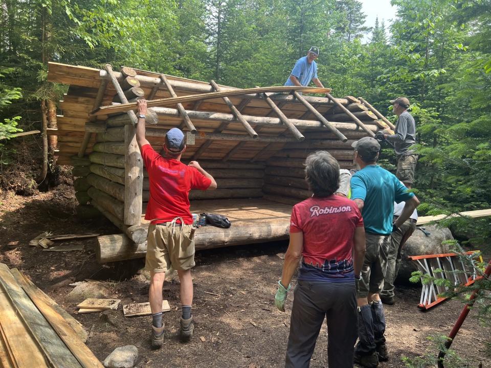 A group of people working to fix a lean-to