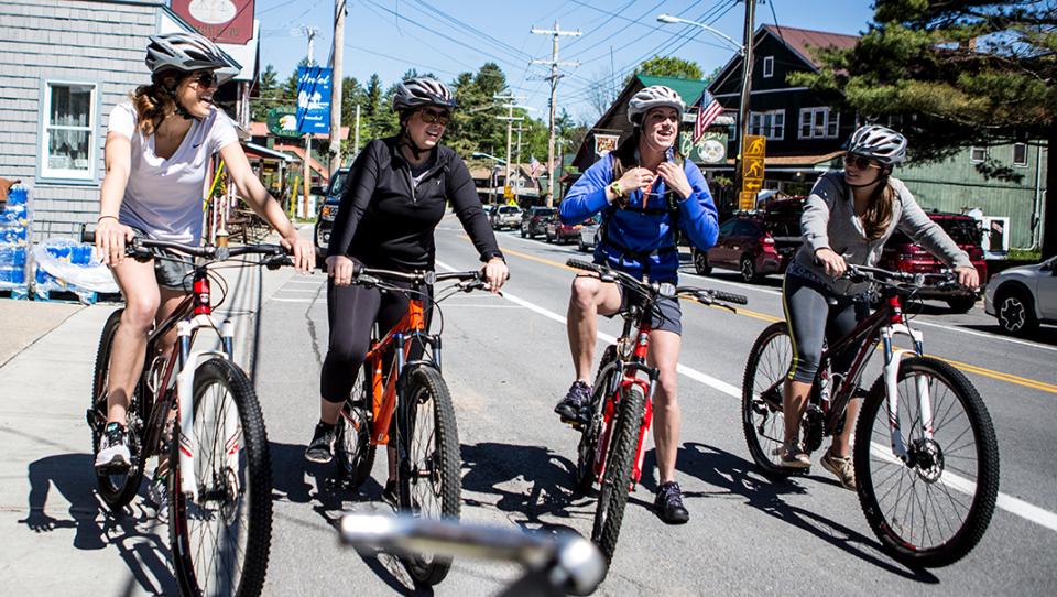 A group of women get ready to bike in a small town.