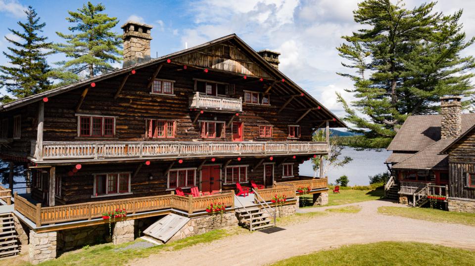 A drone shot of a sprawling lodge with red trim on a great camp site.