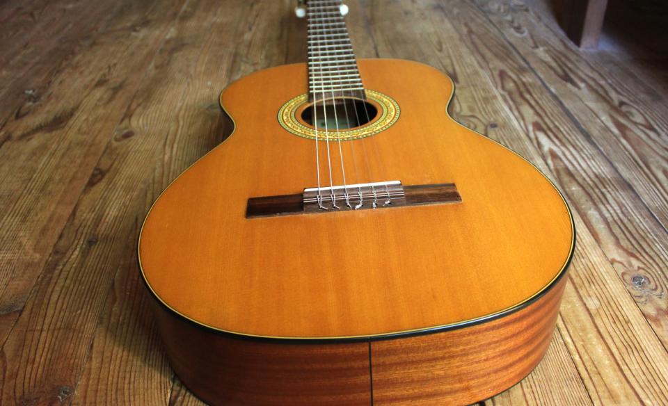 a guitar laying on a hardwood floor