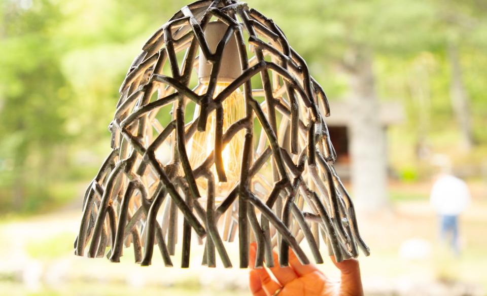 a hanging lamp that is made out of metal but in the design of twigs surrounding the light