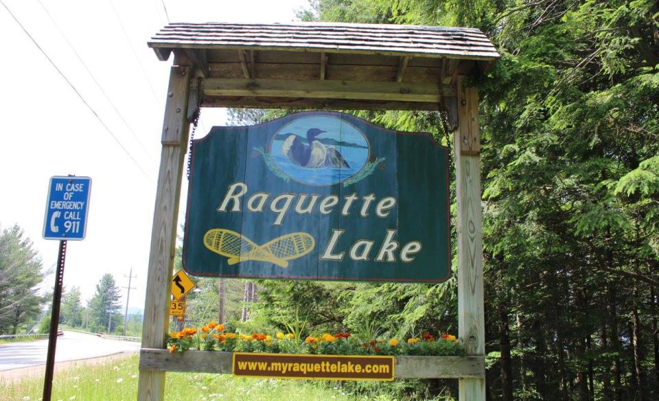 The sign that hangs by the roadside welcoming people to Raquette Lake