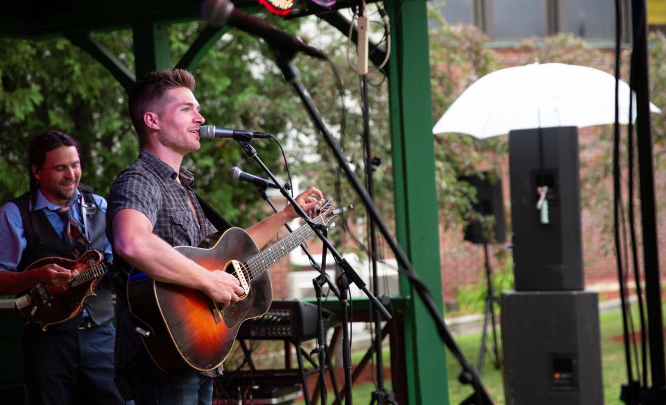 Outdoor live music with man playing guitar and singing