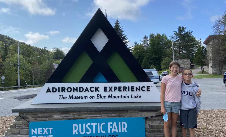 Two children standing in front of the ADX sign