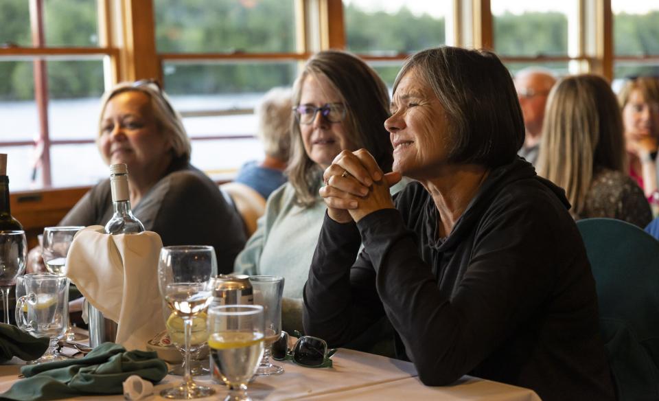 Three women sitting at a table on the WW Durant with glasses of wine in front of them having a good time.