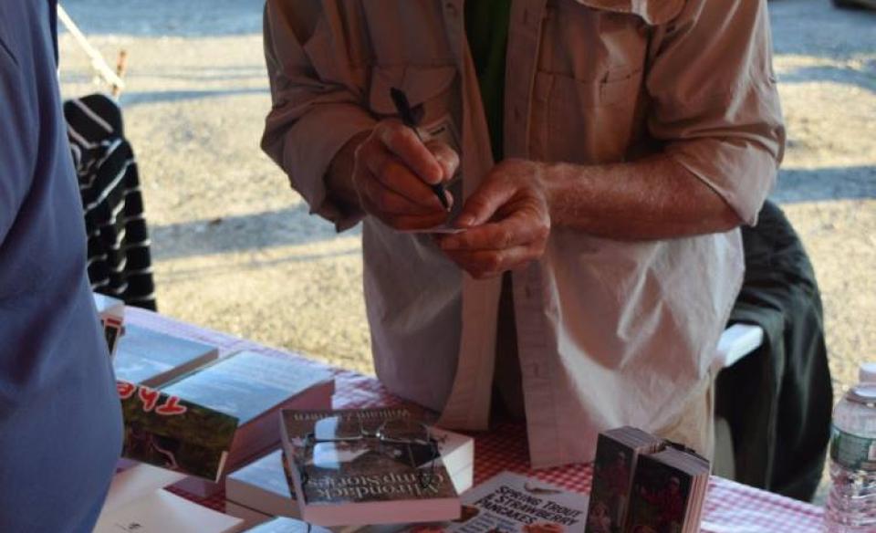 An author signs a book at a table