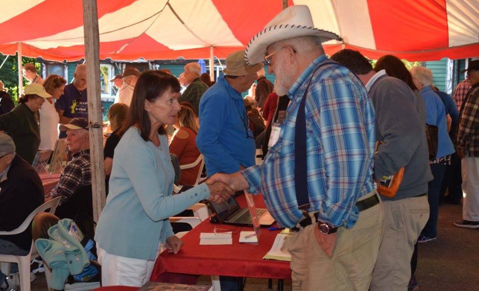 Photograph of people gathered under a large tent