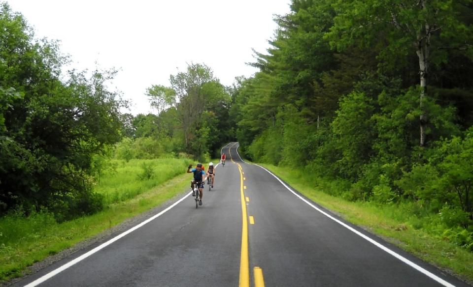 A couple bikers on a newly paved road