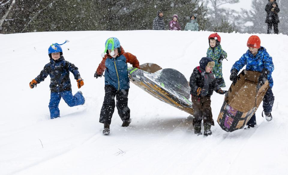 Kids running winter snow sled